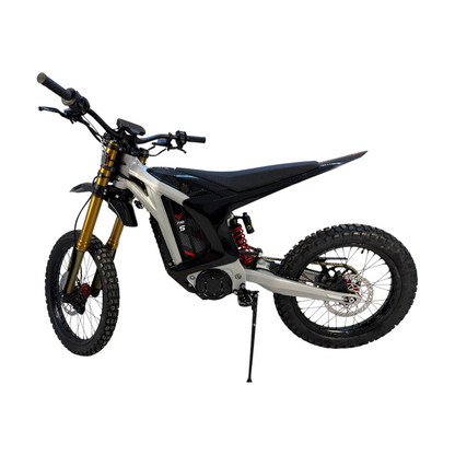 A sleek silver and black electric dirt bike with gold forks and a red rear spring.