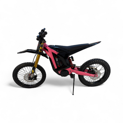 A bold hot pink and black electric dirt bike featuring gold forks and a red rear spring.